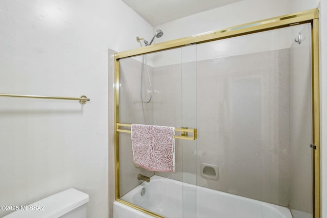 bathroom with toilet and bath / shower combo with glass door