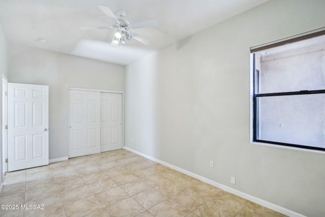 unfurnished bedroom featuring multiple windows, light tile patterned flooring, ceiling fan, and a closet