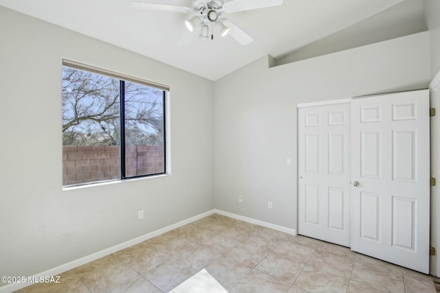 unfurnished bedroom featuring light tile patterned flooring, lofted ceiling, ceiling fan, and a closet