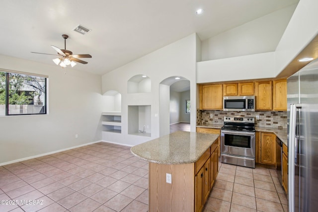 11215 N Via Rancho Naranjo, Oro Valley, AZ 85737 - kitchen featuring light tile patterned floors, stainless steel appliances, visible vents, light stone countertops, and built in shelves