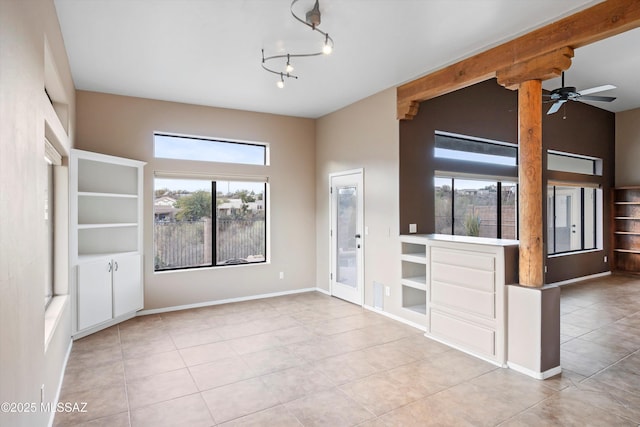 tiled spare room with ceiling fan with notable chandelier