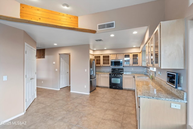 kitchen featuring light stone counters, sink, and stainless steel appliances