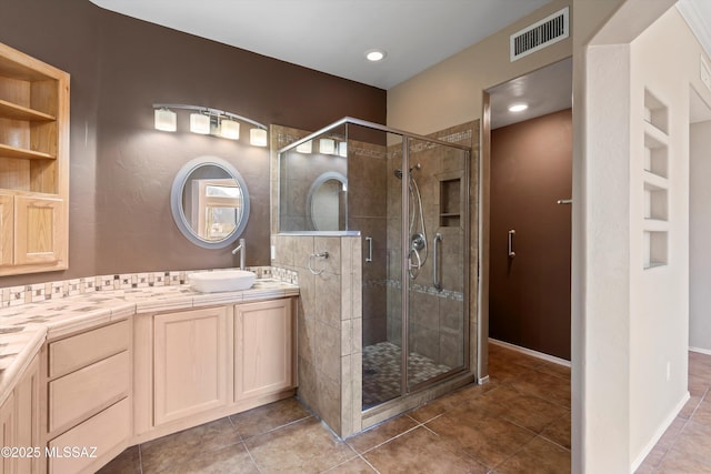 bathroom with tile patterned floors, vanity, and an enclosed shower