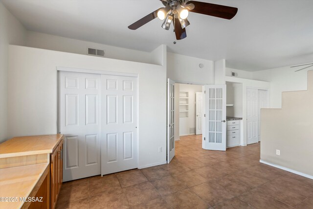 unfurnished bedroom featuring ceiling fan and french doors