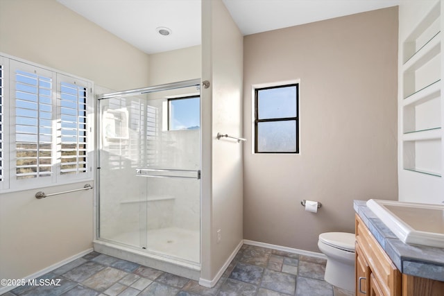 bathroom featuring vanity, a shower with shower door, and toilet