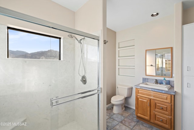 bathroom featuring vanity, toilet, and a shower with shower door