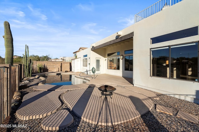 back of house featuring a patio area and a fire pit