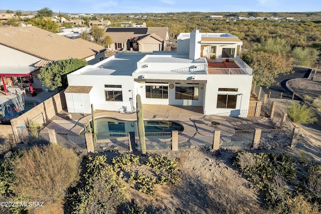 rear view of house featuring a fenced in pool and a patio area