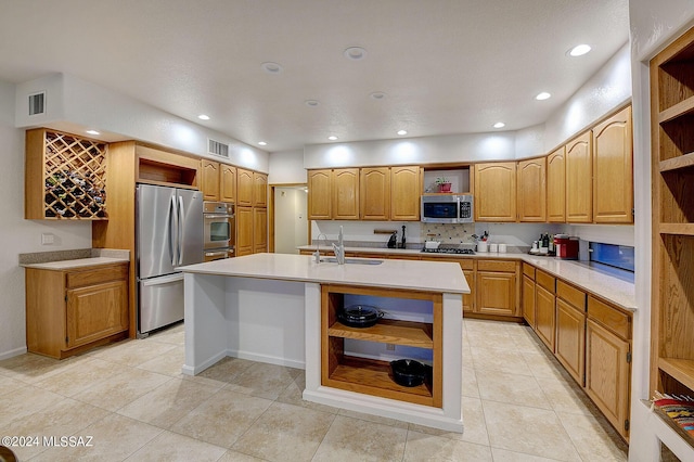 kitchen featuring light tile patterned floors, sink, stainless steel appliances, and an island with sink