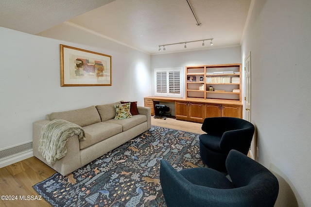 living room with crown molding, hardwood / wood-style floors, and track lighting