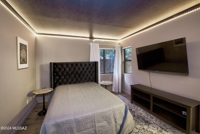 bedroom with hardwood / wood-style flooring and a textured ceiling