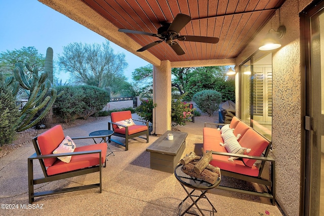 patio terrace at dusk featuring an outdoor living space and ceiling fan