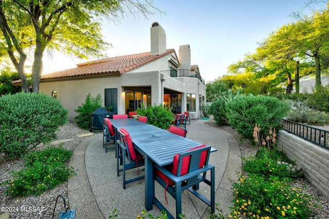 rear view of property featuring a patio area and a balcony