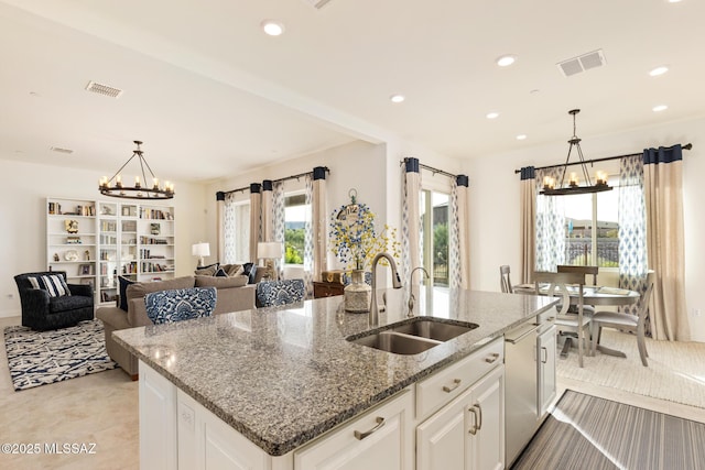 kitchen featuring an inviting chandelier, white cabinetry, decorative light fixtures, and sink