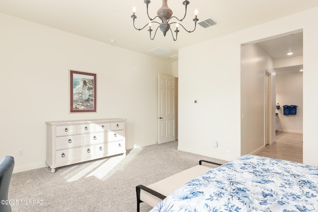 bedroom featuring light colored carpet, connected bathroom, and a chandelier