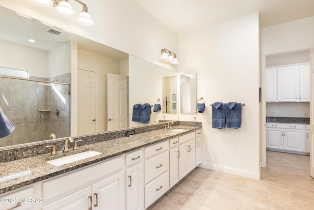 bathroom with a shower with shower door and vanity