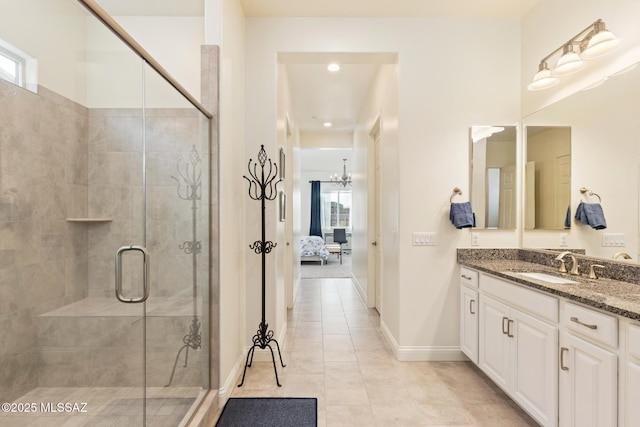 bathroom with walk in shower, vanity, a notable chandelier, and tile patterned floors