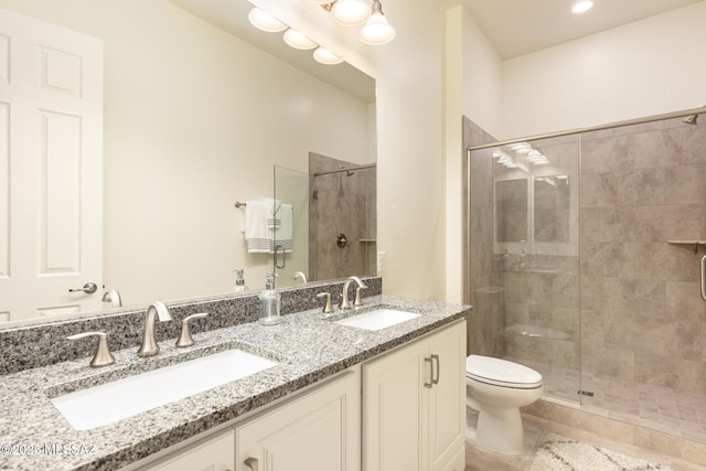 bathroom with a shower with shower door, toilet, vanity, and tile patterned flooring