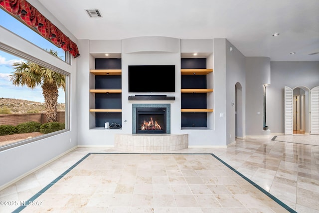 unfurnished living room featuring built in features and a wealth of natural light