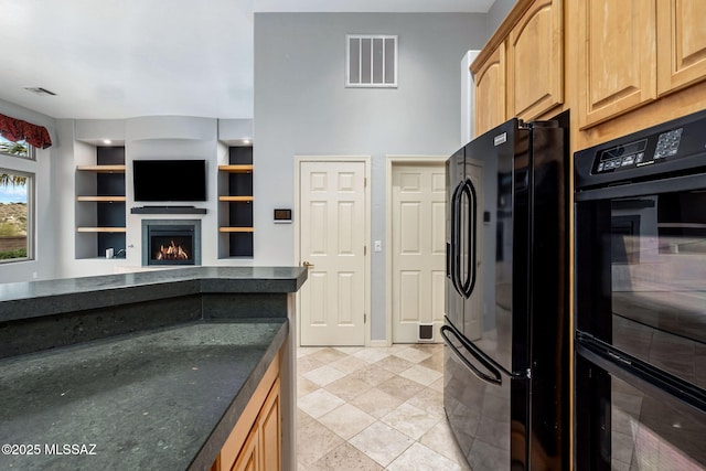 kitchen with light tile patterned flooring, built in shelves, and black appliances