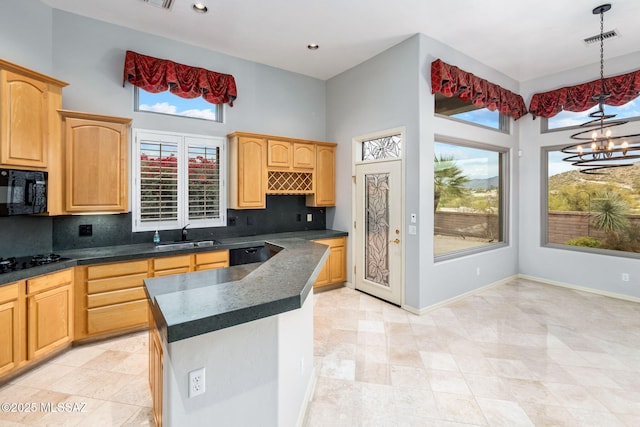 kitchen featuring pendant lighting, black appliances, sink, decorative backsplash, and a chandelier