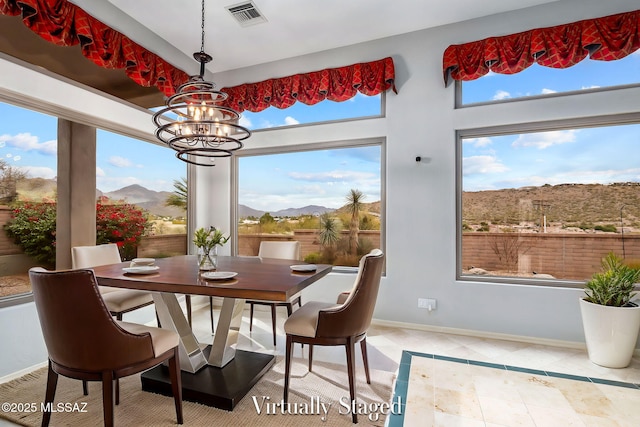 tiled dining area with a mountain view and a notable chandelier