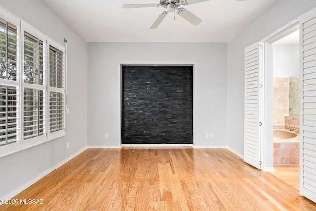 unfurnished bedroom with light wood-type flooring, ensuite bath, and ceiling fan