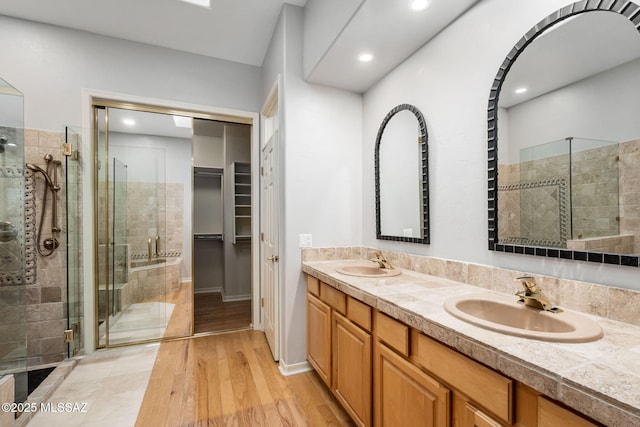 bathroom featuring a shower with door, vanity, and hardwood / wood-style flooring