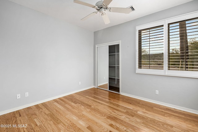 unfurnished bedroom with ceiling fan, light wood-type flooring, and a closet