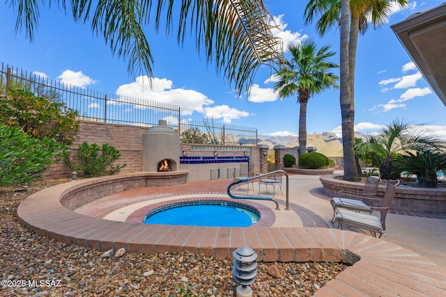 view of swimming pool featuring an in ground hot tub, a mountain view, and a patio area