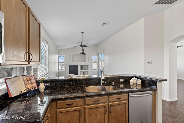 kitchen with sink, dishwasher, ceiling fan, dark parquet floors, and dark stone counters