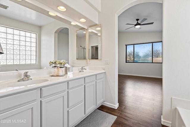 bathroom with wood-type flooring, lofted ceiling, a bathtub, vanity, and ceiling fan