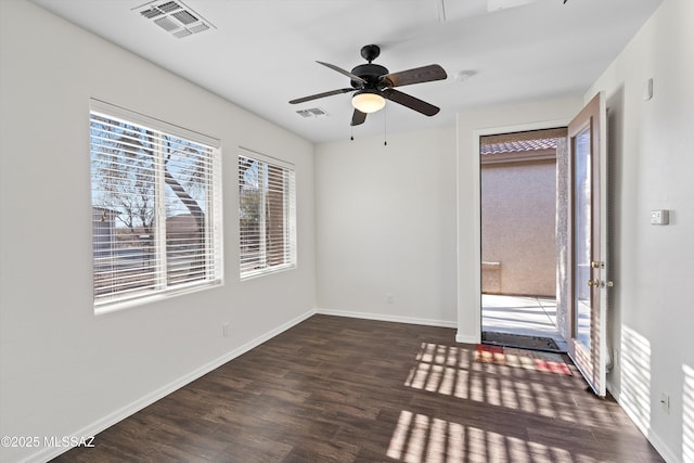 empty room featuring dark wood-type flooring and ceiling fan