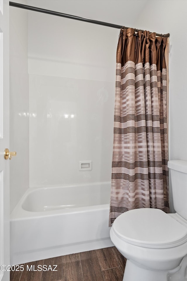 bathroom with toilet, hardwood / wood-style floors, and shower / bath combo