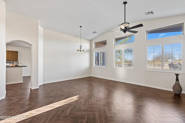 empty room with dark parquet floors, high vaulted ceiling, and ceiling fan