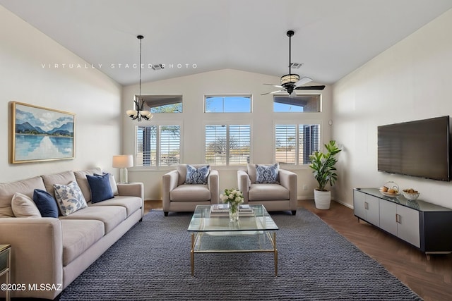 living room with dark parquet flooring, ceiling fan with notable chandelier, and high vaulted ceiling