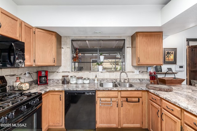 kitchen featuring black appliances, backsplash, light stone counters, and sink