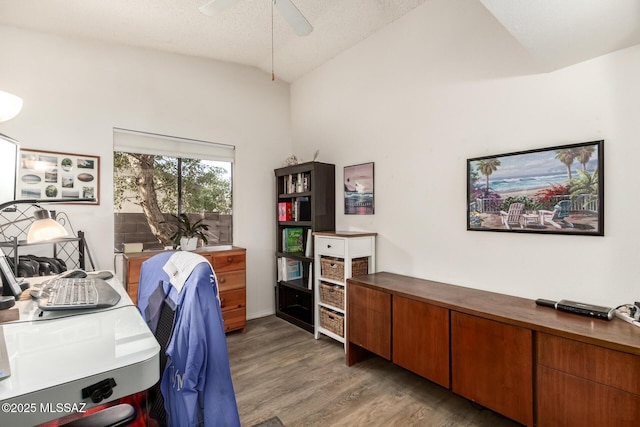 home office featuring lofted ceiling, light wood-type flooring, ceiling fan, and a textured ceiling