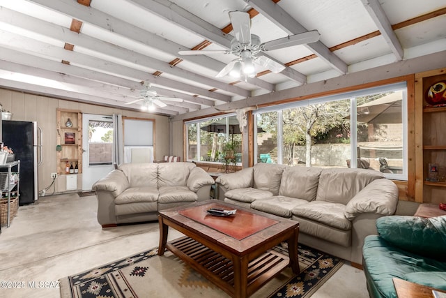 living room featuring beam ceiling, ceiling fan, and wooden walls