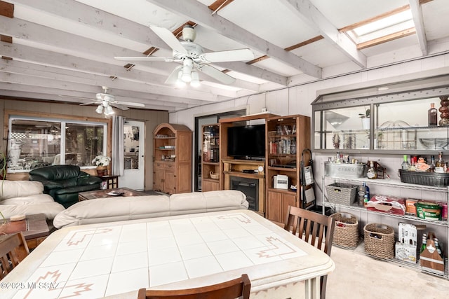 interior space with beam ceiling, ceiling fan, and wood walls