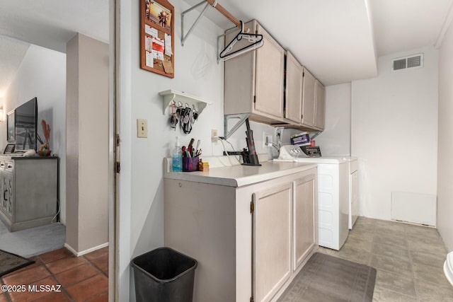 laundry room with separate washer and dryer and cabinets