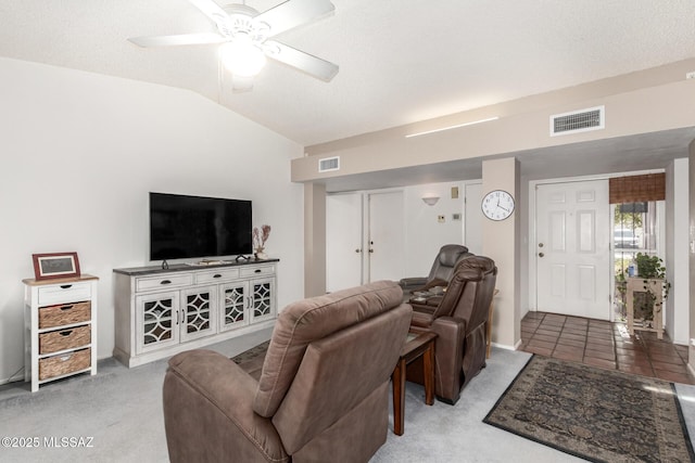 living room with lofted ceiling, a textured ceiling, carpet floors, and ceiling fan