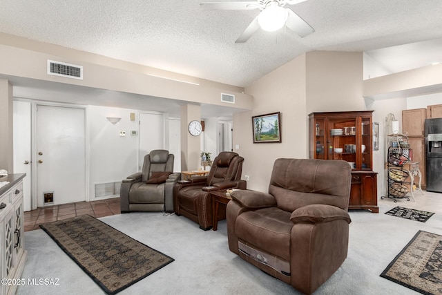 living room featuring lofted ceiling, light tile patterned flooring, a textured ceiling, and ceiling fan