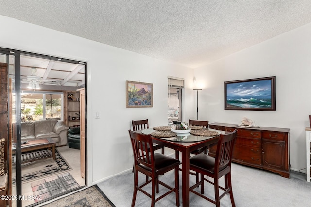 dining space featuring a textured ceiling and light colored carpet