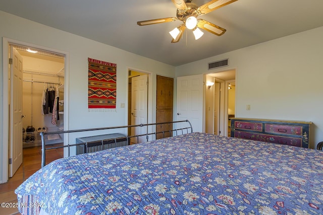 bedroom featuring ceiling fan, a spacious closet, radiator heating unit, and a closet