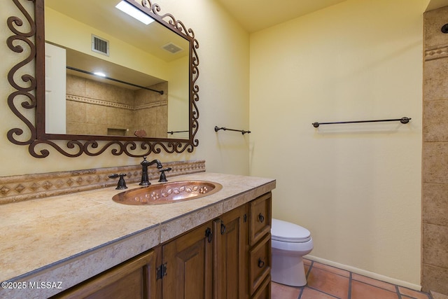 bathroom with tile patterned flooring, vanity, and toilet