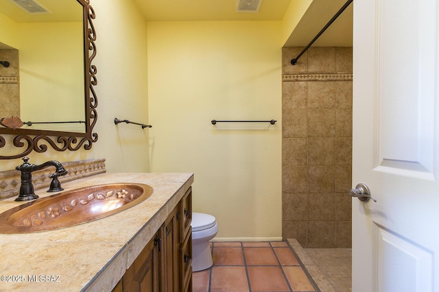 bathroom with a shower, tile patterned flooring, vanity, and toilet