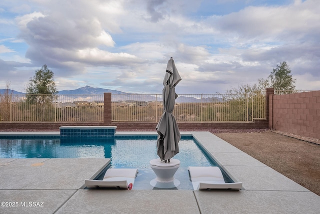 view of swimming pool with a patio and a mountain view