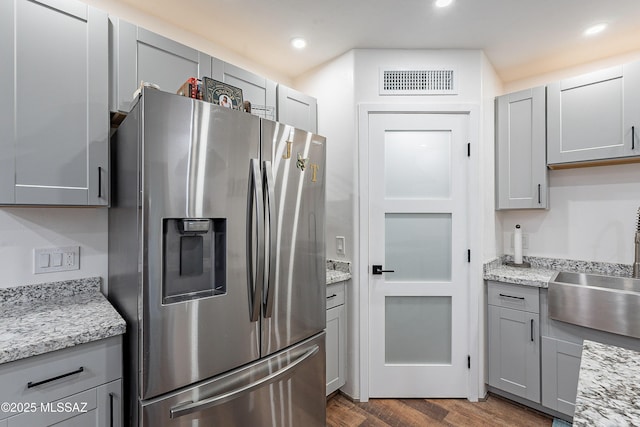 kitchen featuring stainless steel fridge, dark hardwood / wood-style flooring, gray cabinetry, and sink