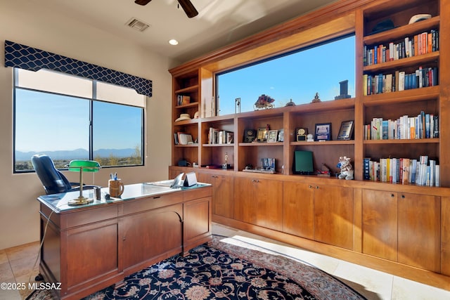 tiled office space with ceiling fan and a mountain view